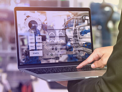 Mann mit Laptop in Industrieanlage