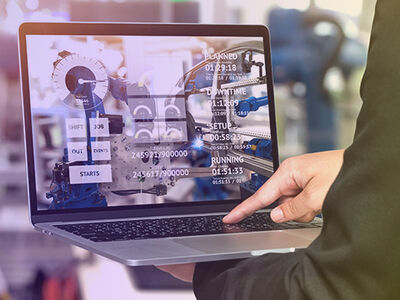 Mann mit Laptop in einer Industrieanlage