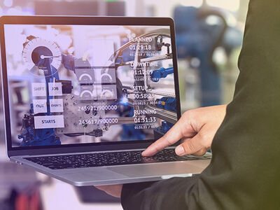 Mann mit Laptop in Industrieanlage
