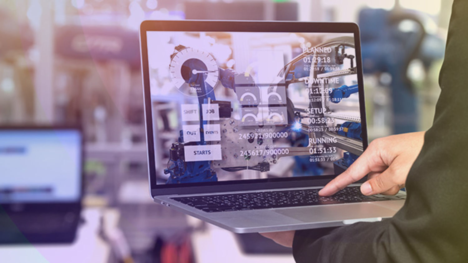 Mann mit Laptop in Industrieanlage