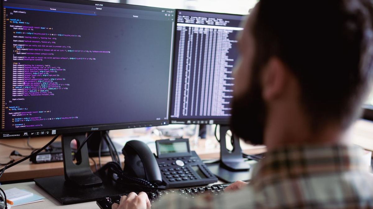 Sysadmin am Arbeitsplatz Ein Systemadministrator sitzt vor einem Monitor