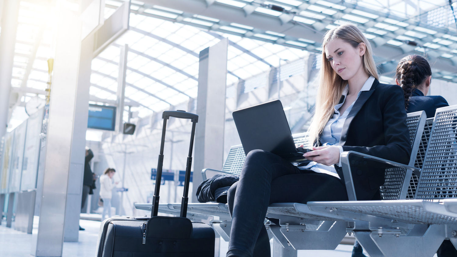 Eine Frau arbeitet an einem Laptop an S-Bahn Haltestelle