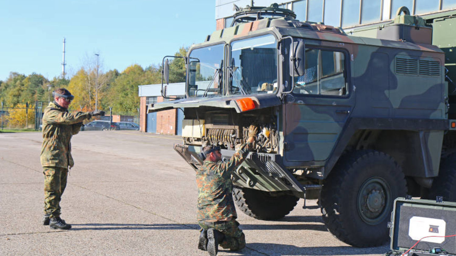 Zwei Männer warten ein Militärfahrzeug