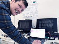 Kryptoforscher Stefan-Lukas Gazdag vor einem Demonstrator für quantensicheres VPN