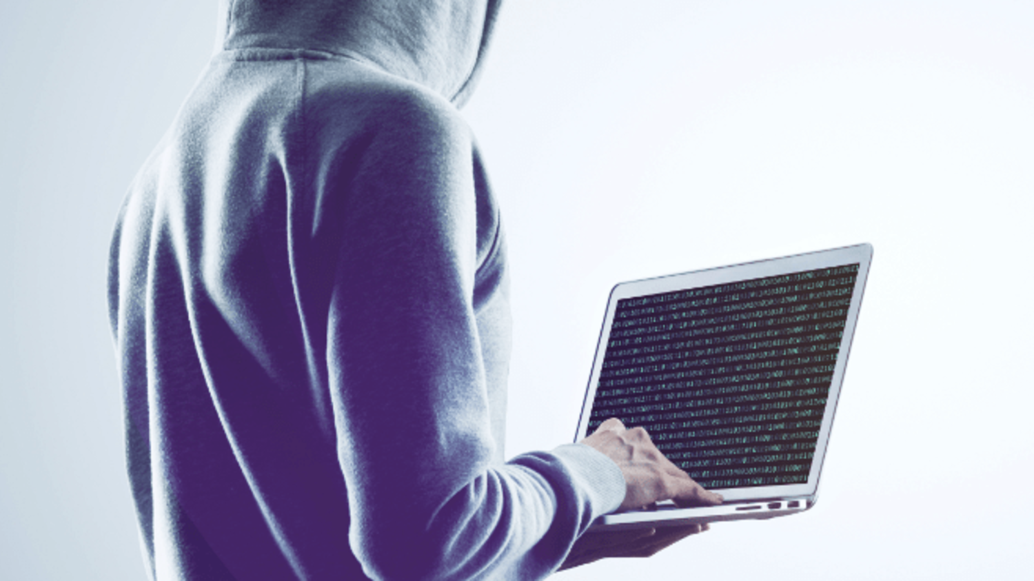 Mann im Kapuzenpullover hält einen geöffneten Laptop