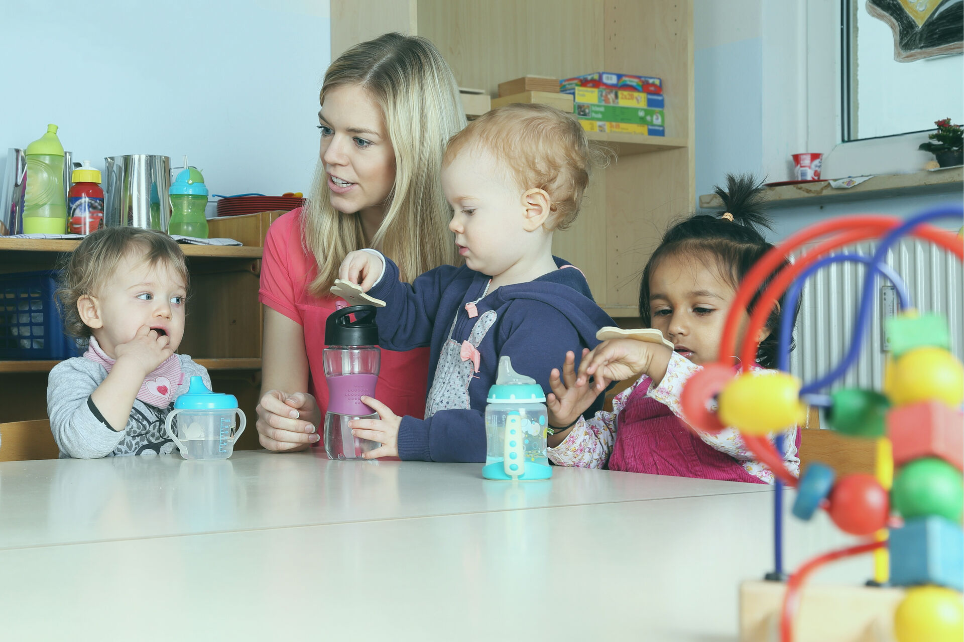 Kinder und Erzieherin an einem Tisch